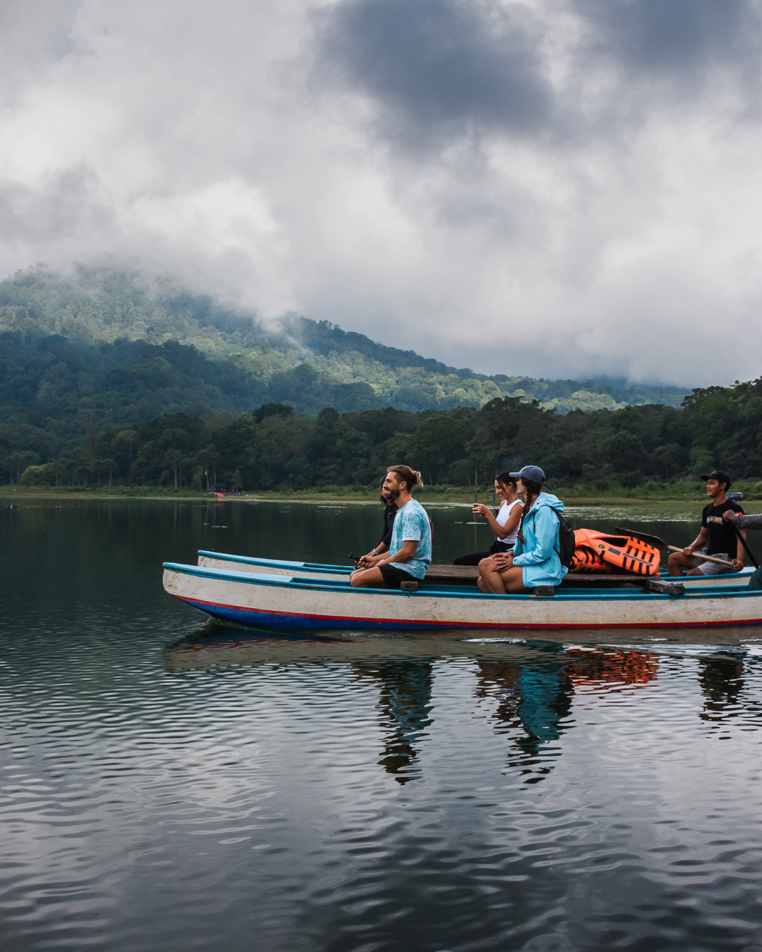 Paseo en bote sobre el lago rodeado de montañas en Munduk